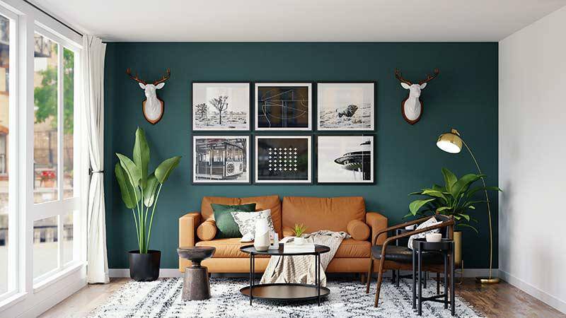 Stylish living room with teal walls, framed artworks, a tan sofa, and decorative plants.