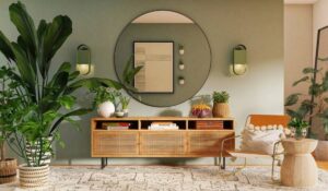 Stylish living room with large plants, a wooden sideboard, and a circular mirror on a green wall.
