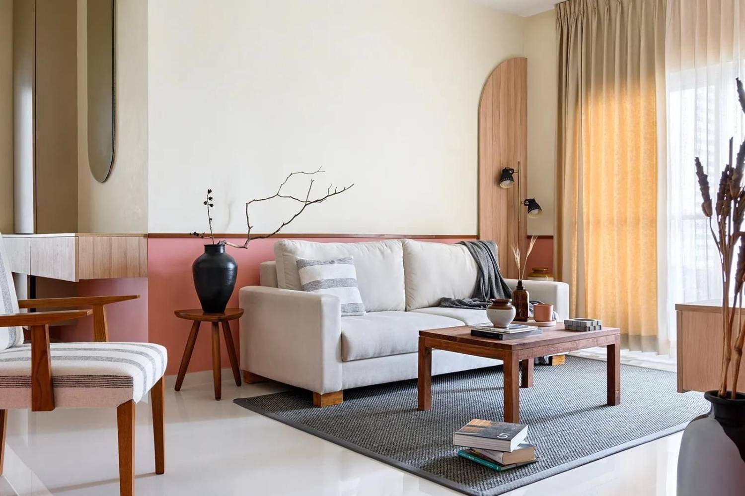 A stylish modern living room with a pastel color scheme, featuring a white sofa, wooden chairs, and elegant decor.