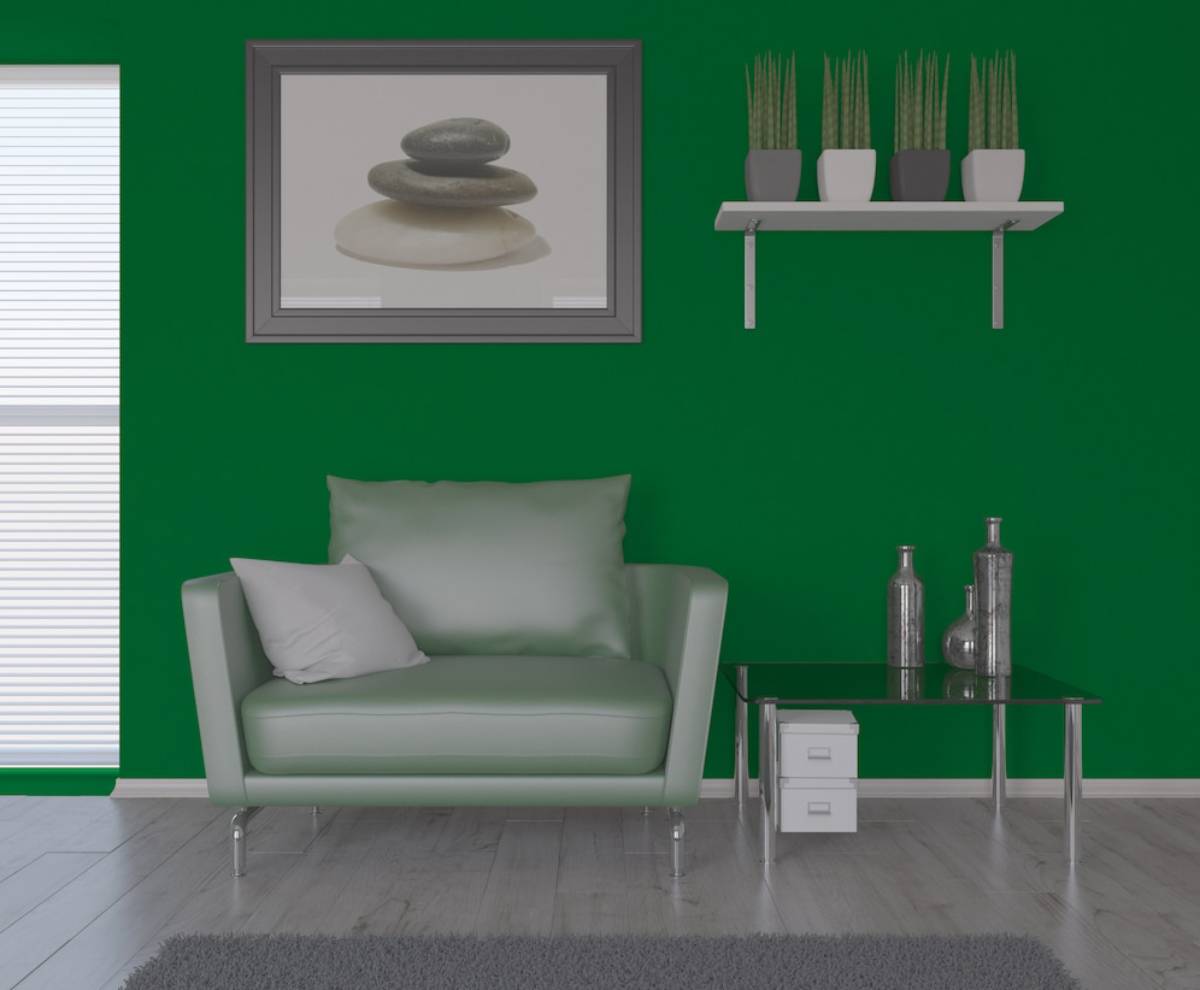  Minimalist living room with a green wall, modern pale green sofa, glass coffee table, and a stone picture frame.
